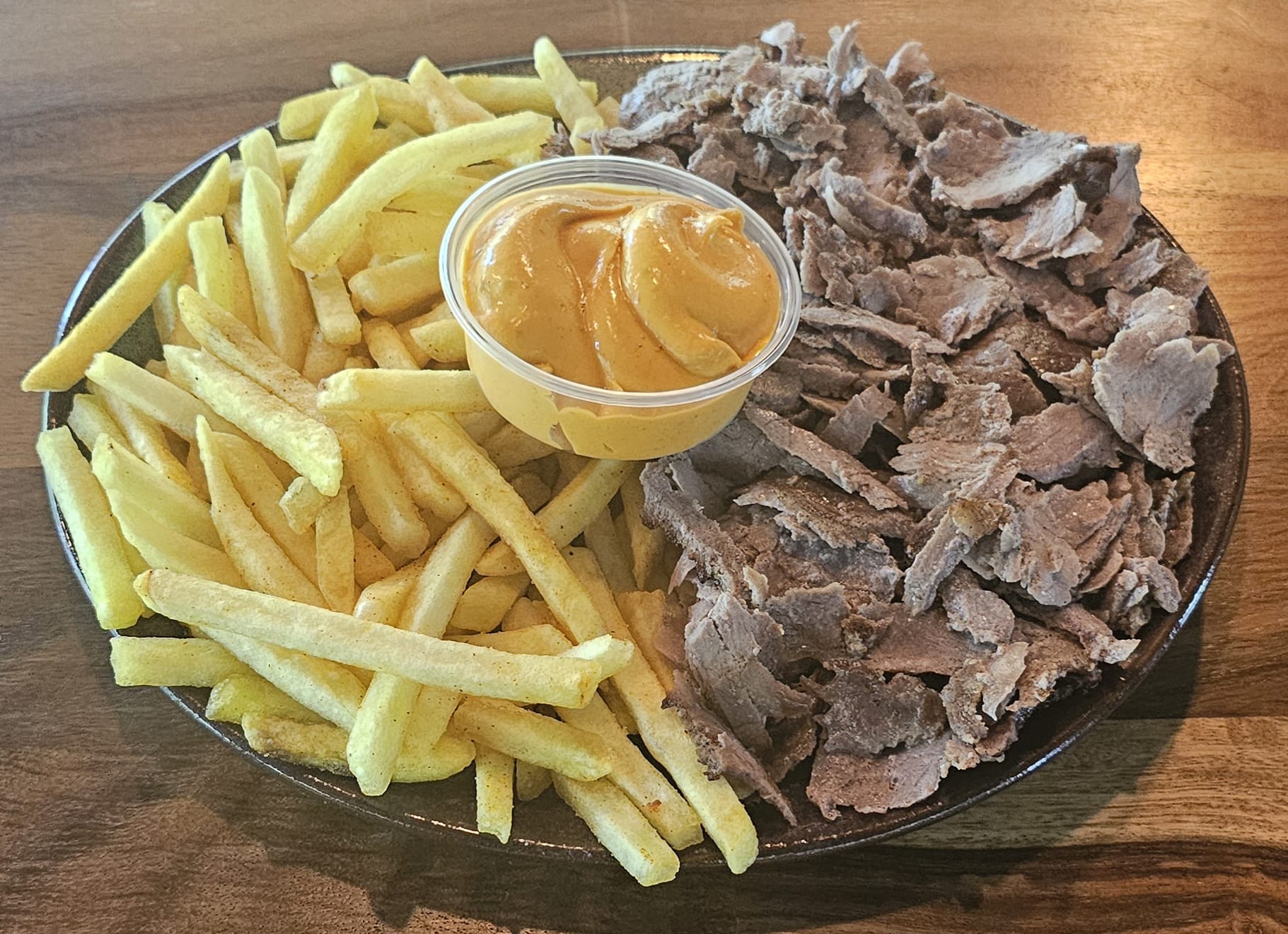 Bord met frieten, vlees en huisgemaakte saus bij Saray Genk